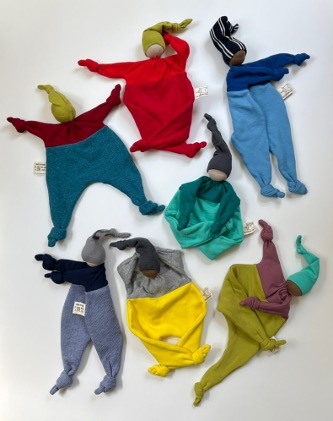 A collection of handmade loveys in different colors and fabrics.